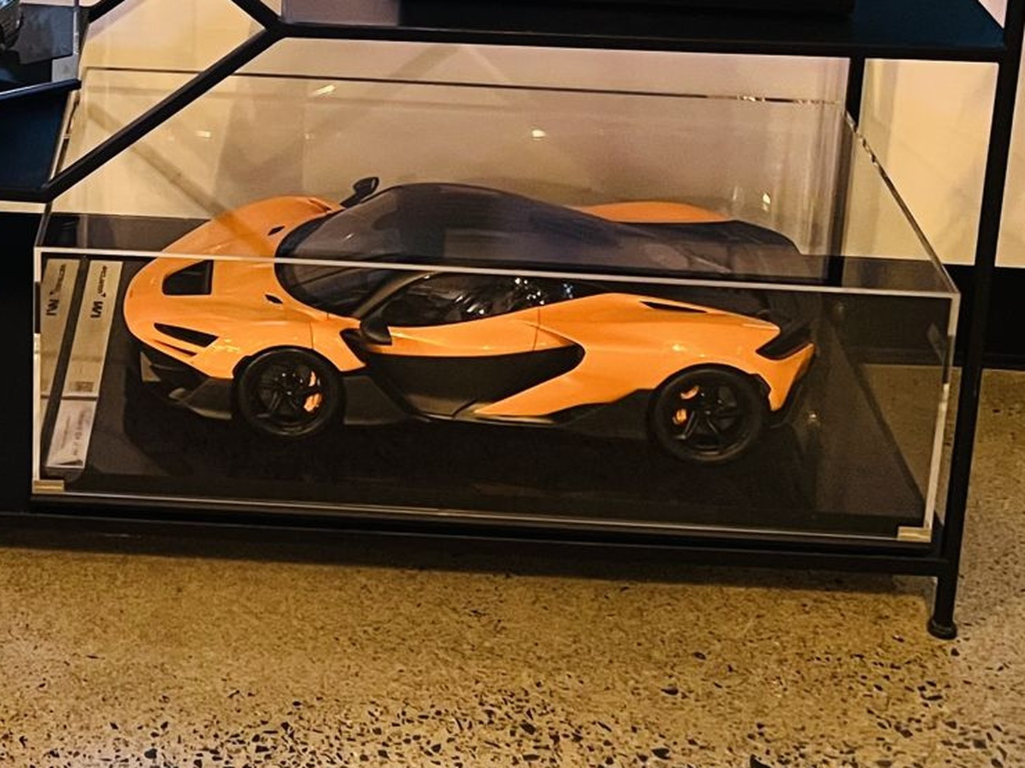 A detailed orange McLaren model memorial in its display case