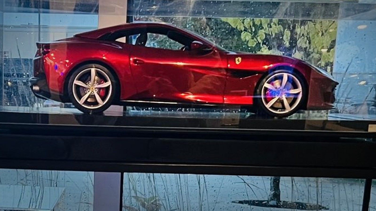 A detailed red Ferrari model memorial in its display case