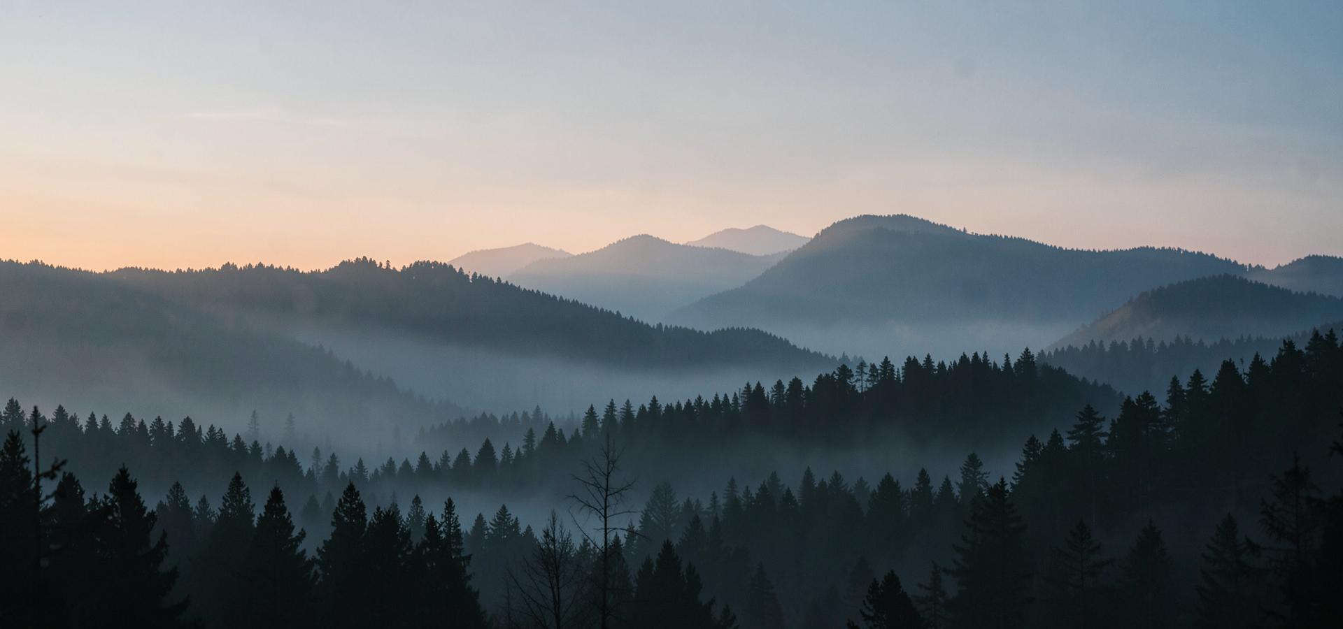 Mountain ridges at sunrise under a wide sky